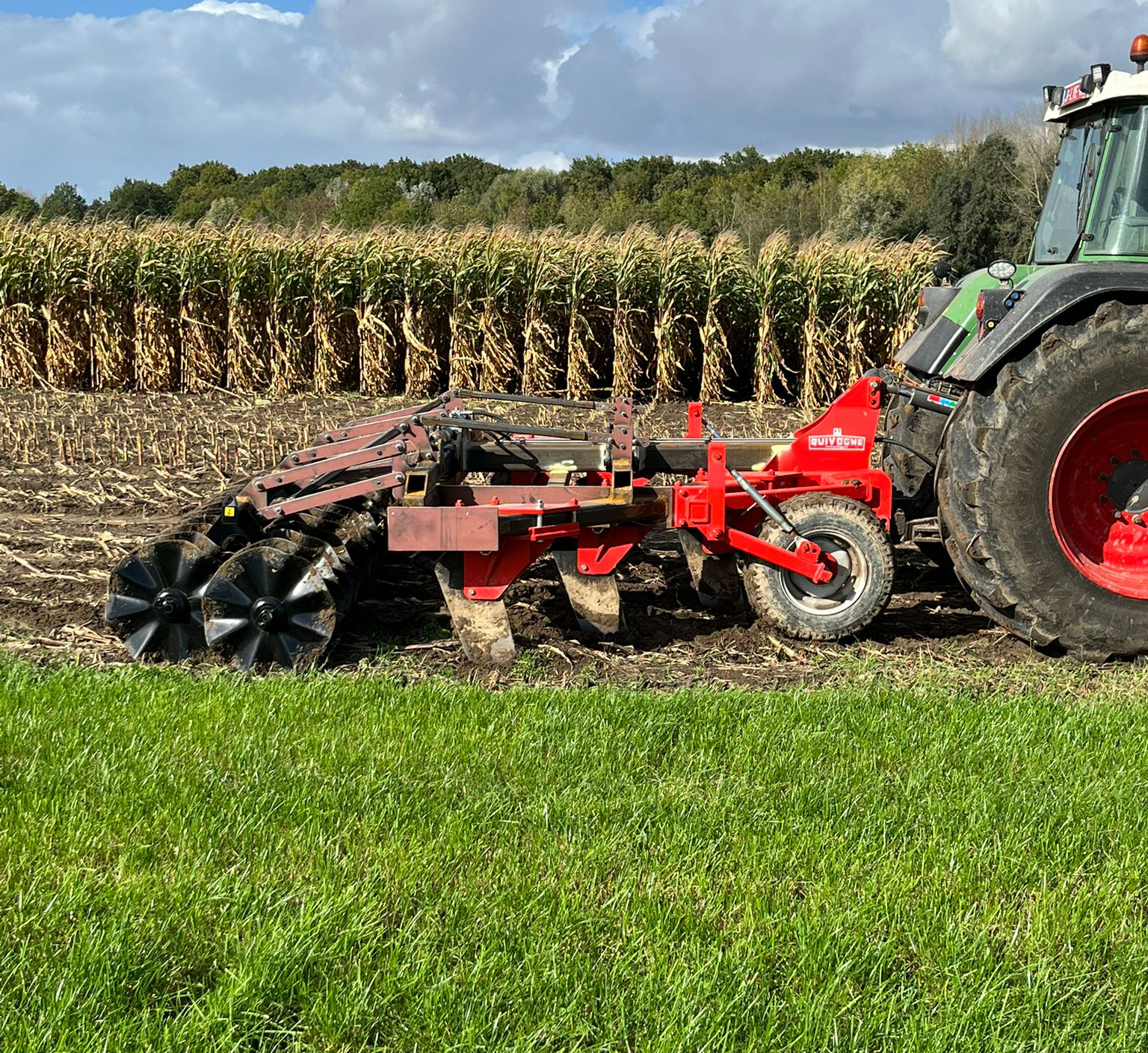 Tractor met stofwolk aan het werk op het veld